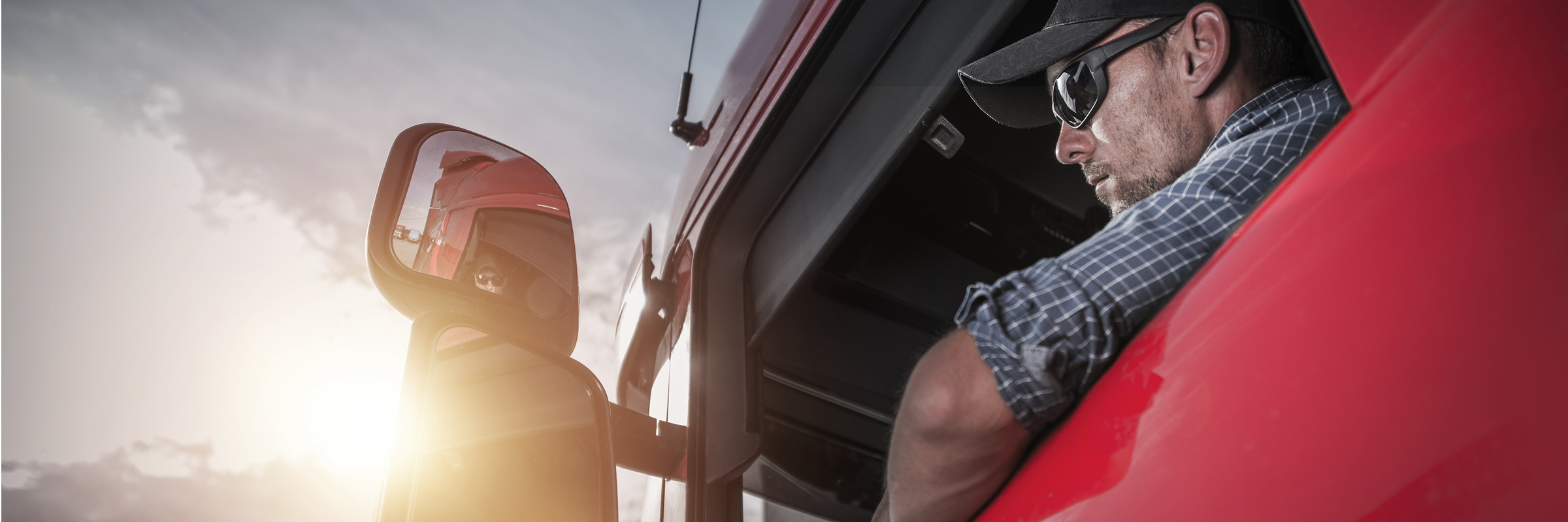 Driver looking in truck's rearview mirror